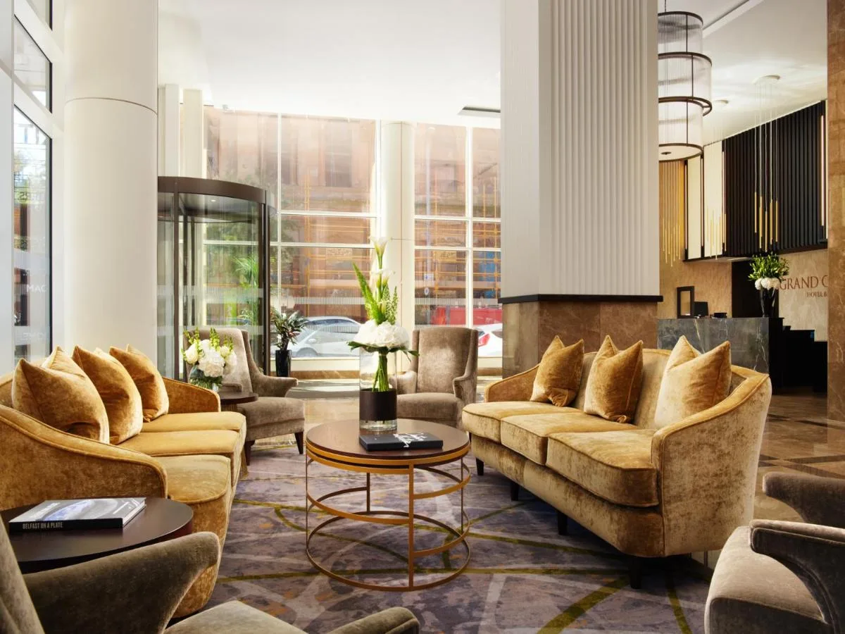 a living room with couches and a table at Grand Central Hotel Belfast in Belfast