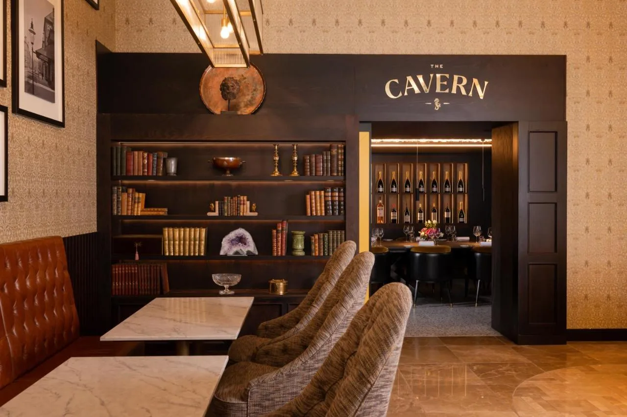 a restaurant with a table and chairs and a bar at Grand Central Hotel Belfast in Belfast